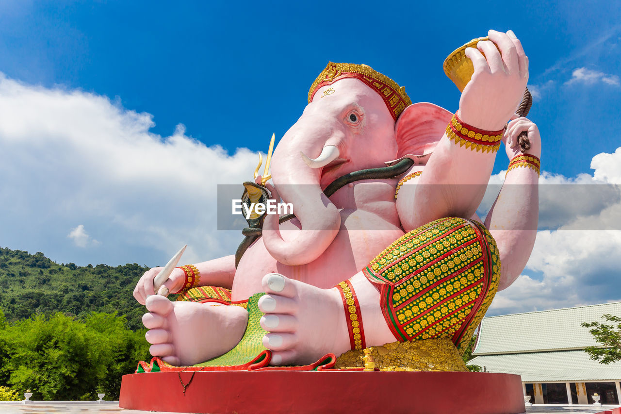 LOW ANGLE VIEW OF WOMAN WITH TOYS AGAINST SKY