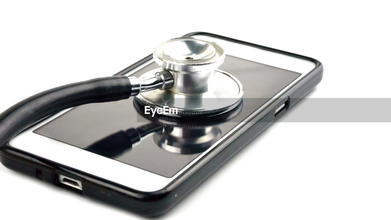 Close-up of stethoscope and mobile phone on table