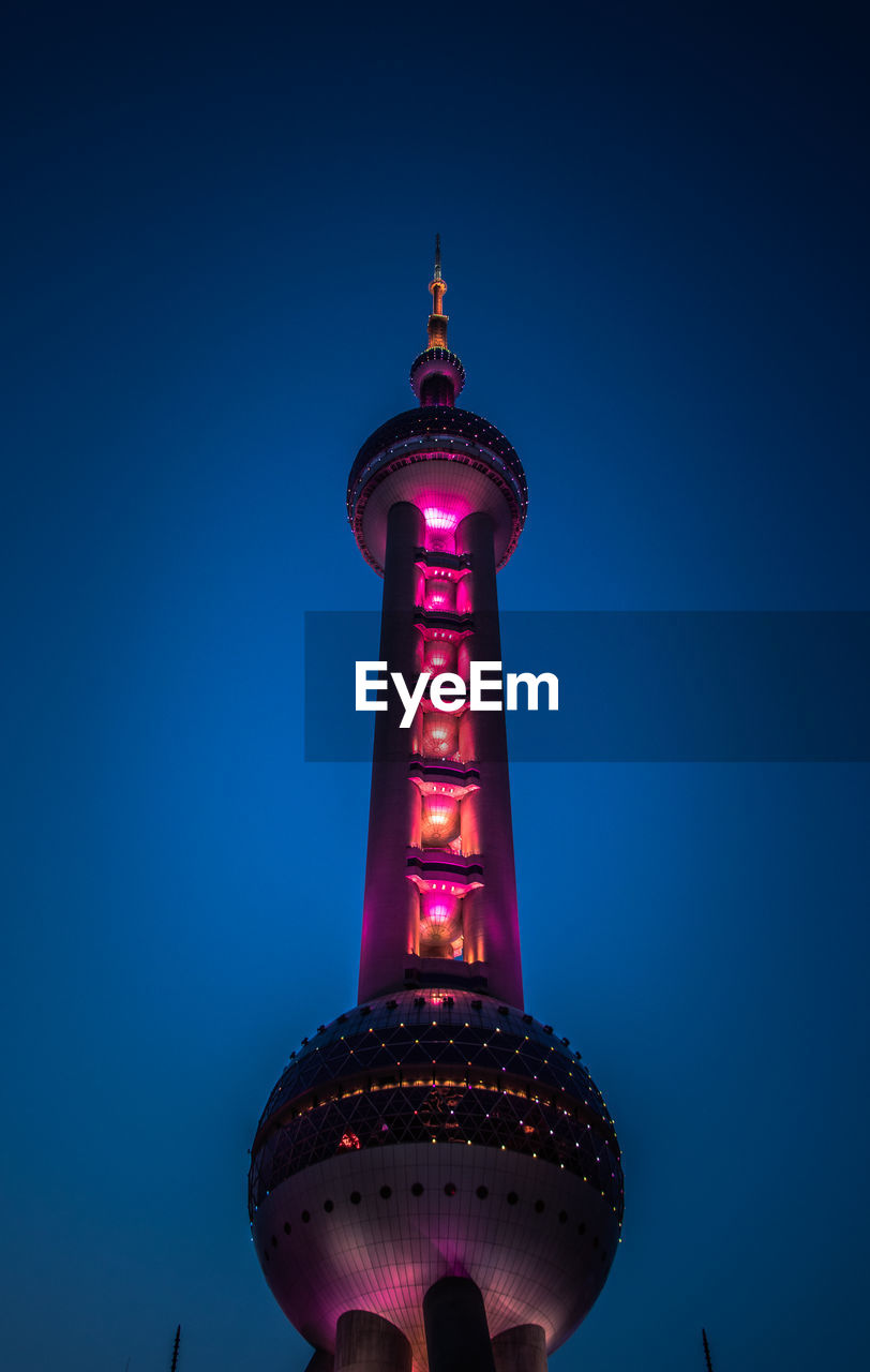 Low angle view of illuminated building against blue sky