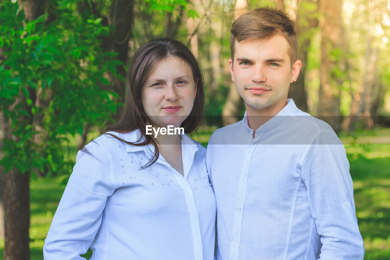 Portrait of young couple standing at park
