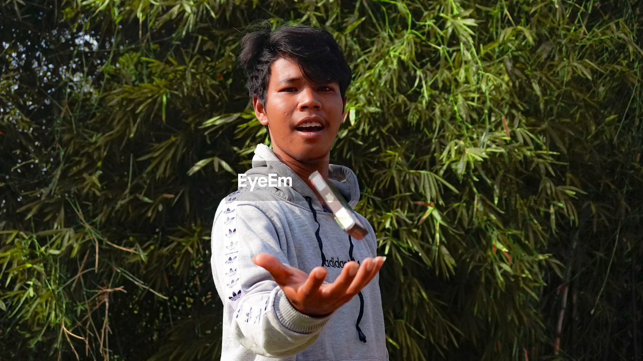 Young man looking away while standing on land