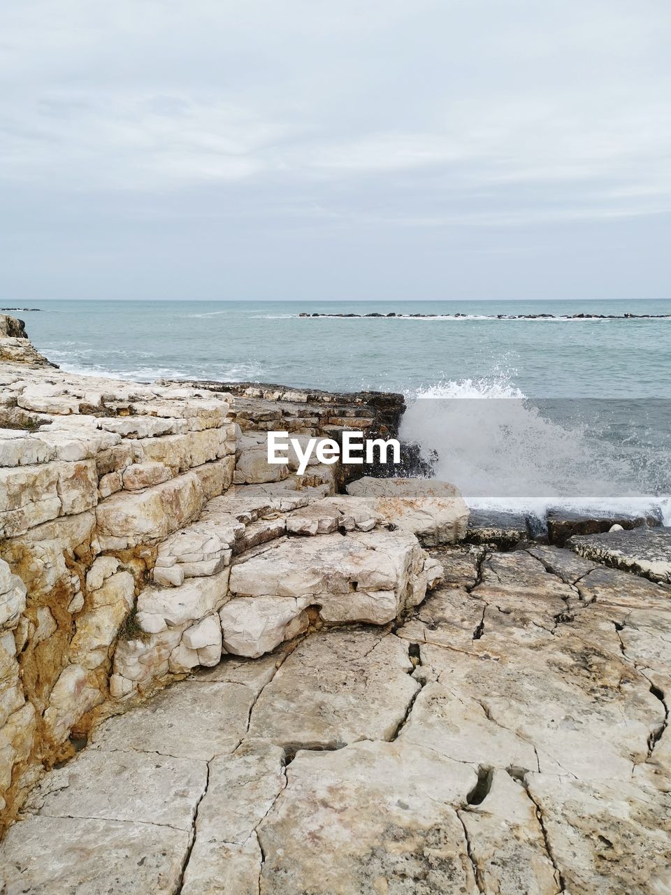 SCENIC VIEW OF ROCKS ON BEACH AGAINST SKY