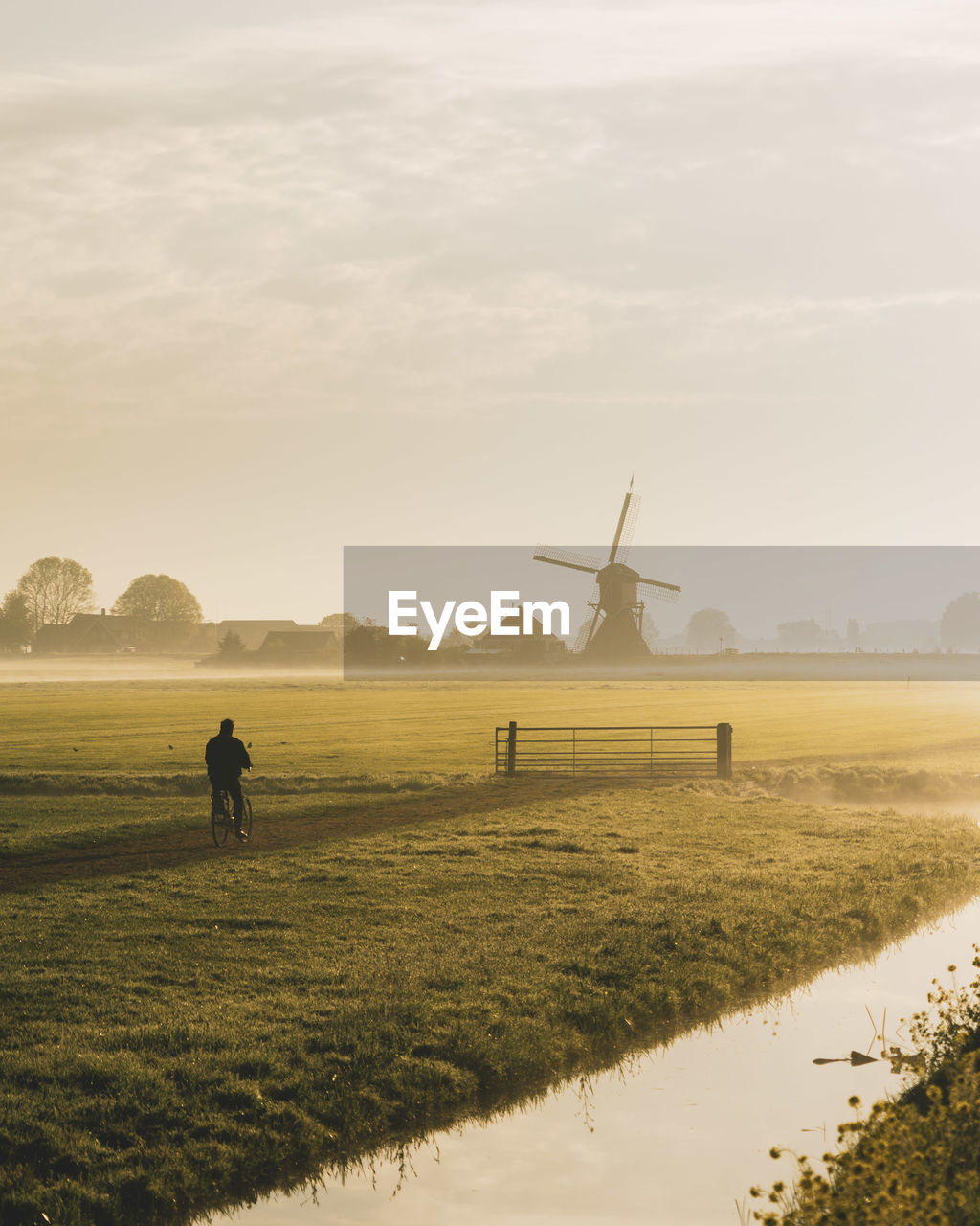 VIEW OF WINDMILL ON FIELD AGAINST SKY