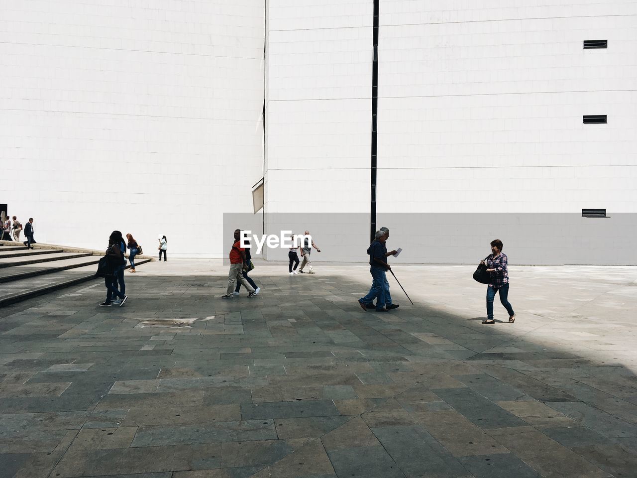 PEOPLE WALKING IN FRONT OF BUILDING