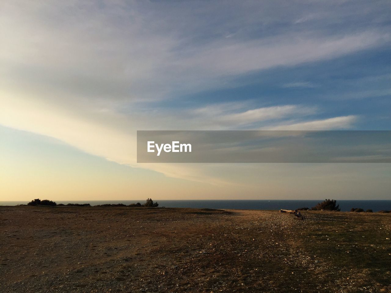 Scenic view of beach against cloudy sky