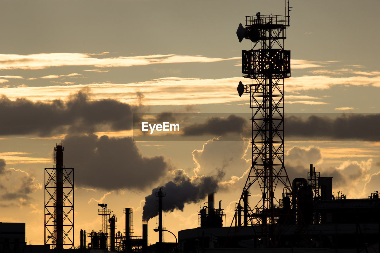 SILHOUETTE OF CRANES AGAINST SKY AT SUNSET