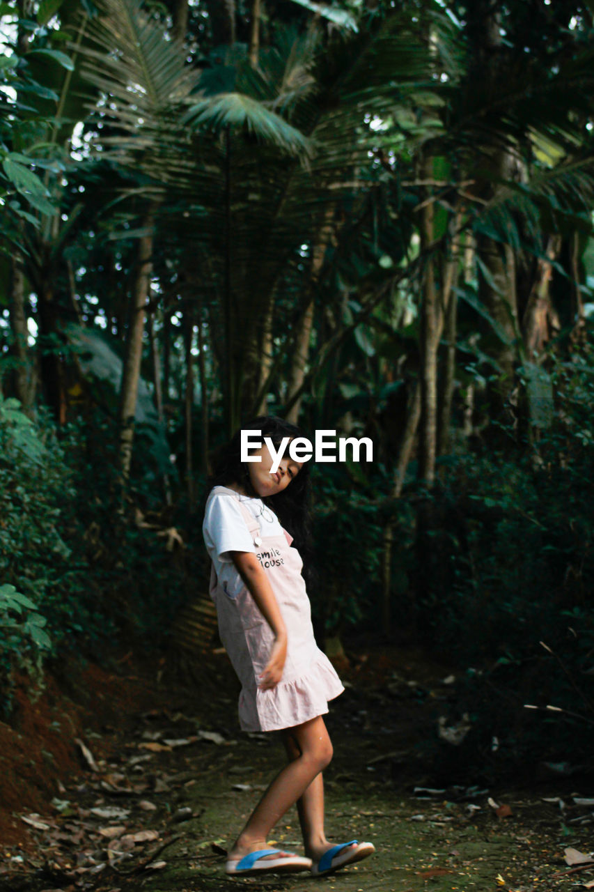 Full length of woman standing in forest