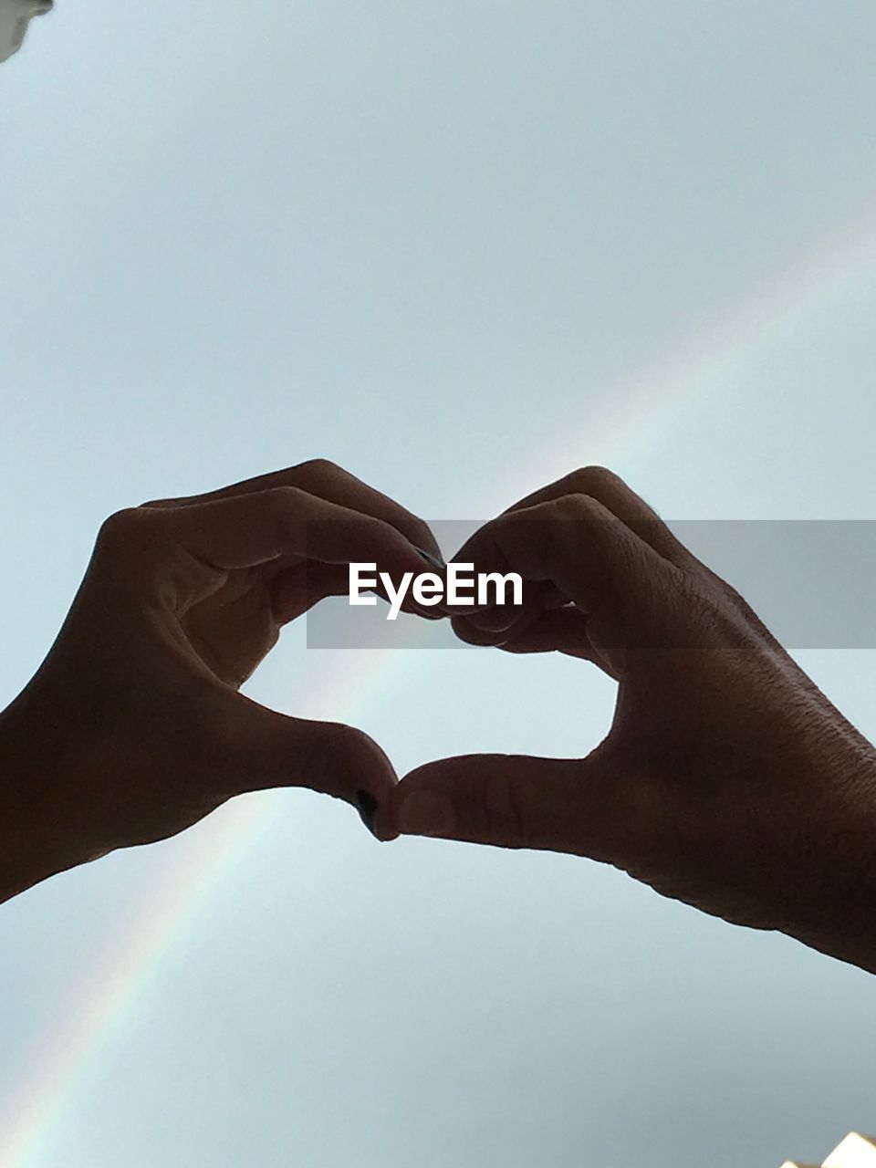 LOW ANGLE VIEW OF HANDS HEART SHAPE AGAINST CLEAR SKY