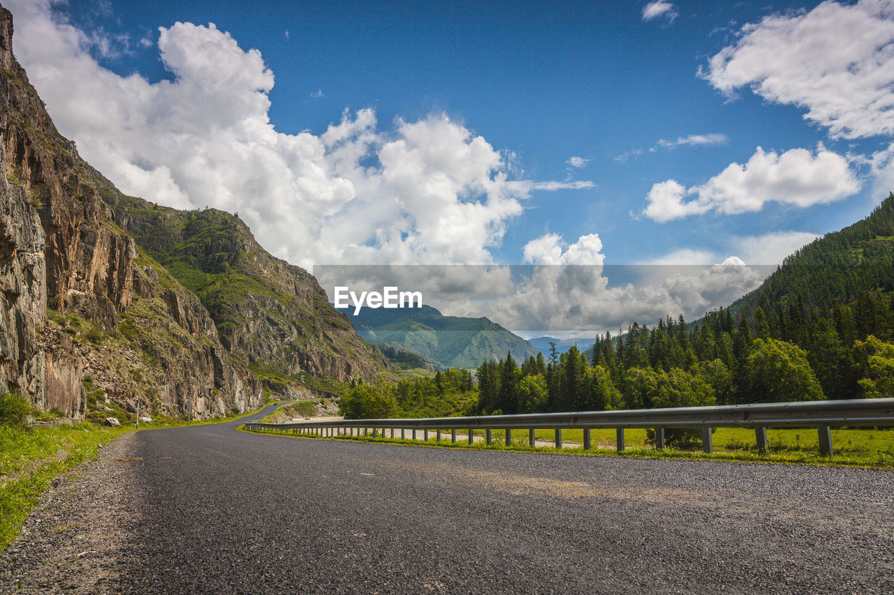 PANORAMIC VIEW OF ROAD AMIDST MOUNTAINS AGAINST SKY