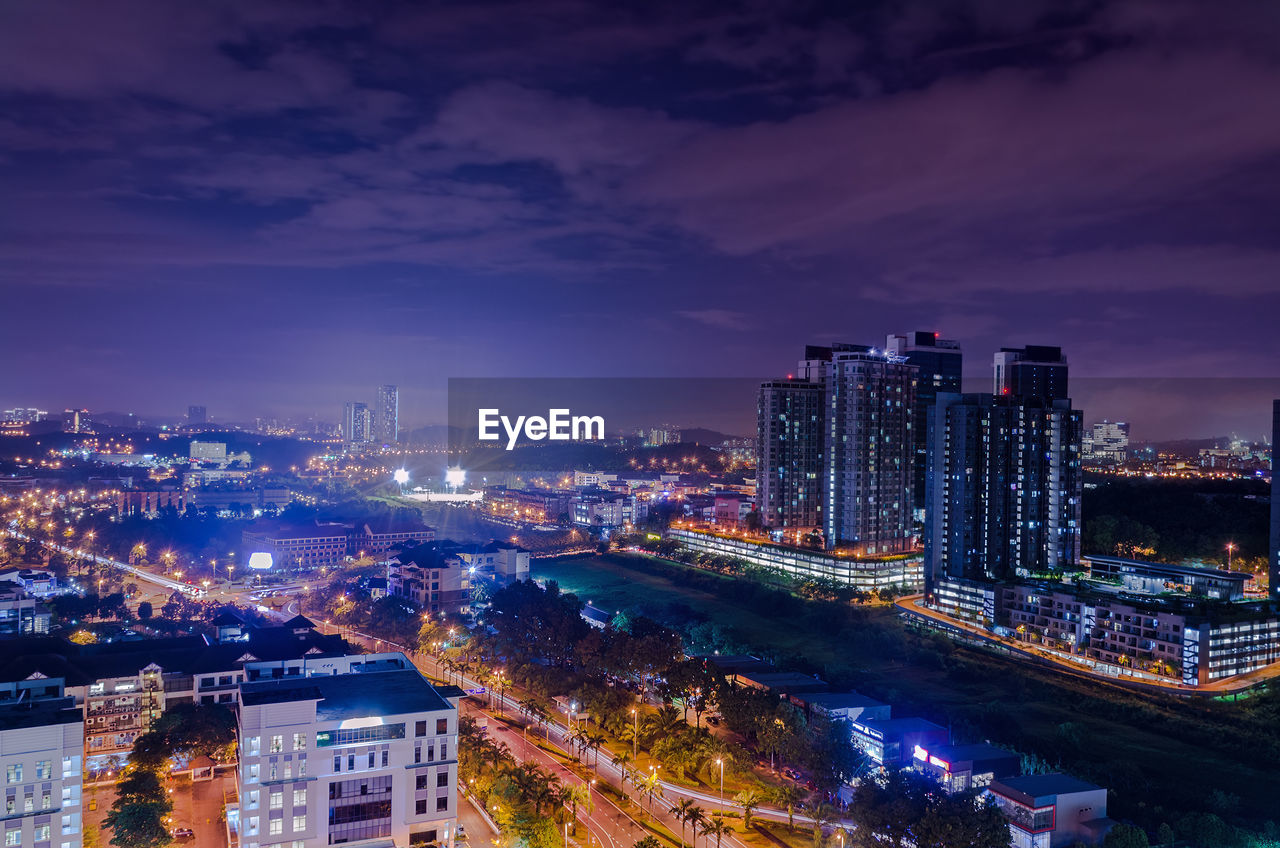 High angle view of illuminated buildings against sky at night