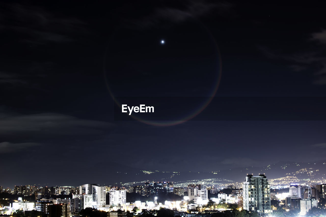 Illuminated cityscape against sky at night