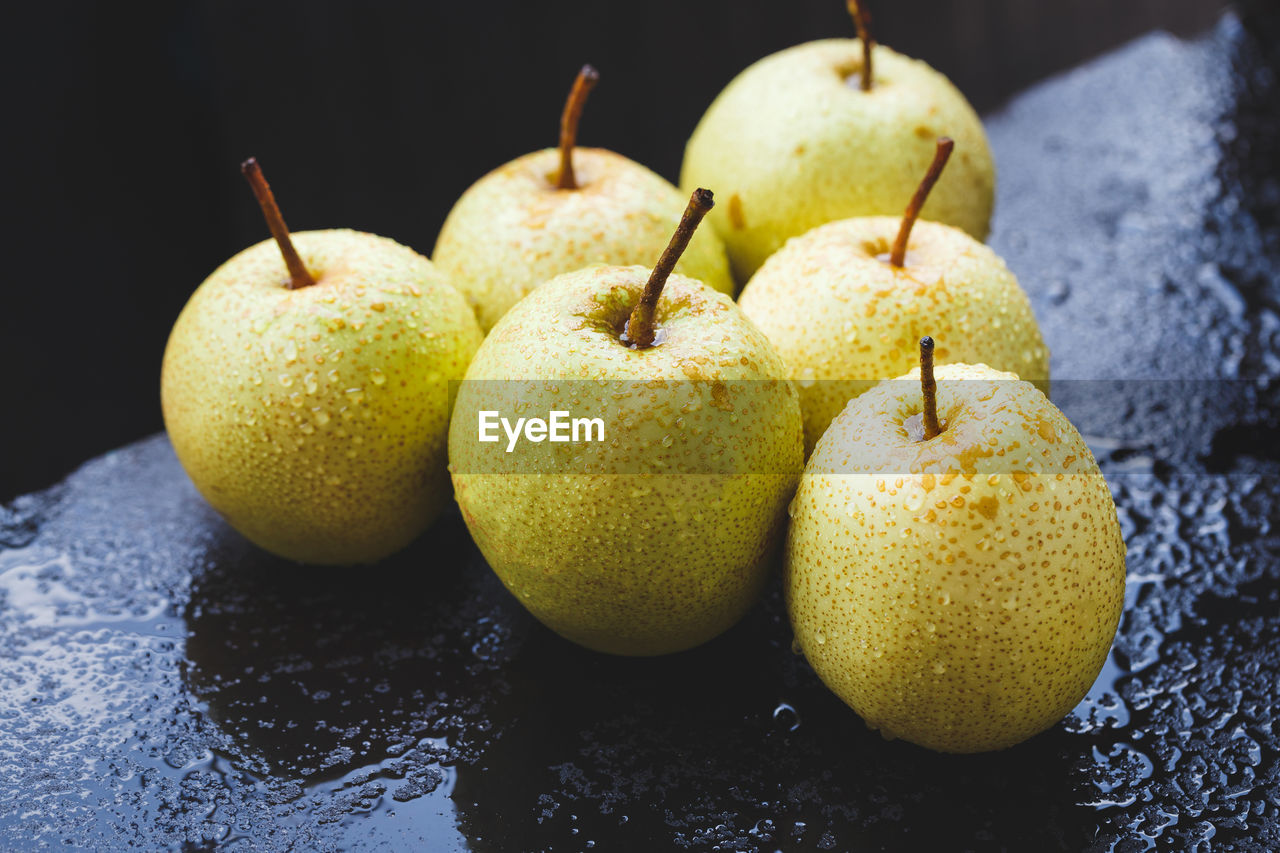 Close-up of granny smith apples on wet marble