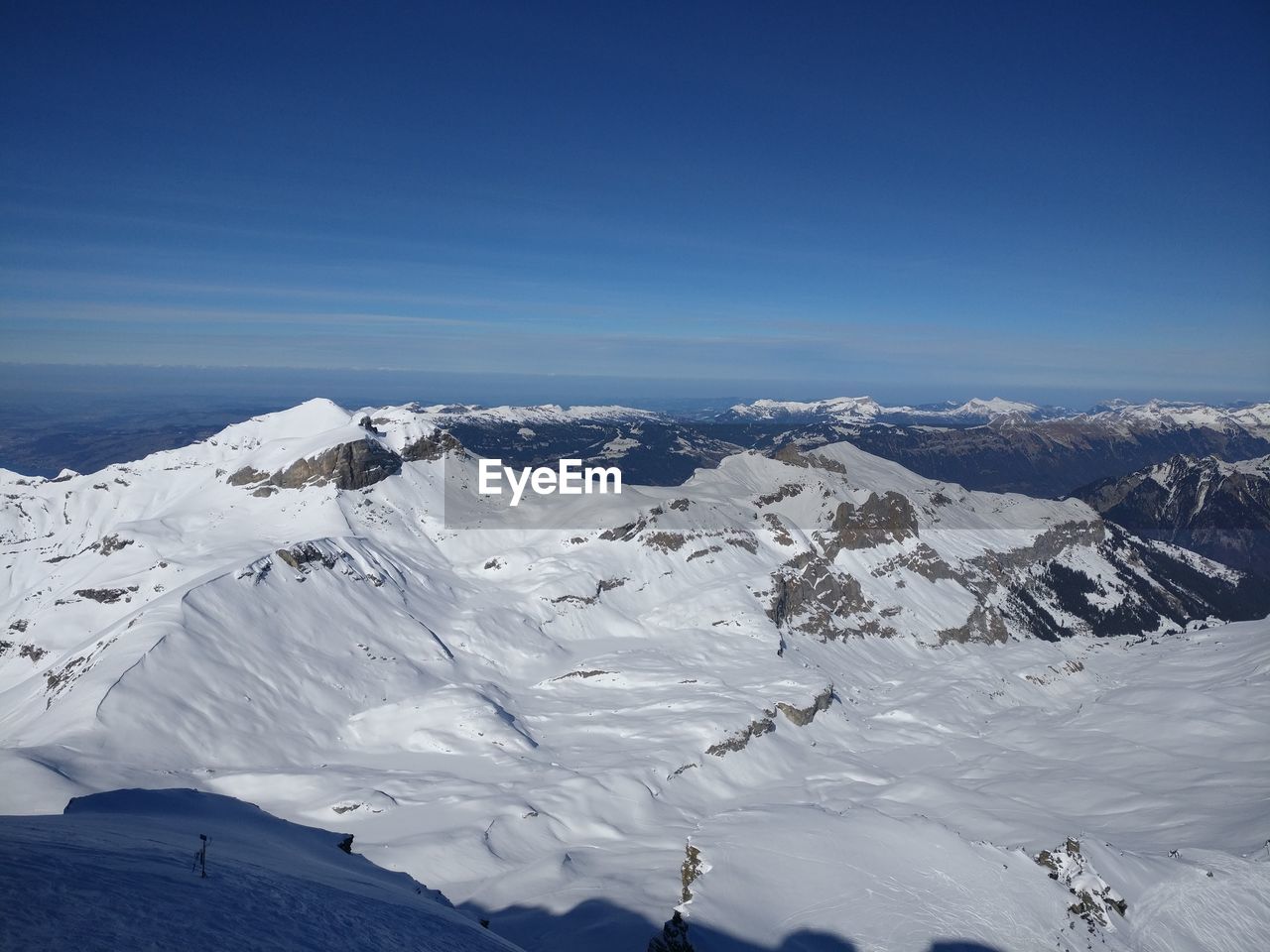 Scenic view of snowcapped mountains against clear blue sky