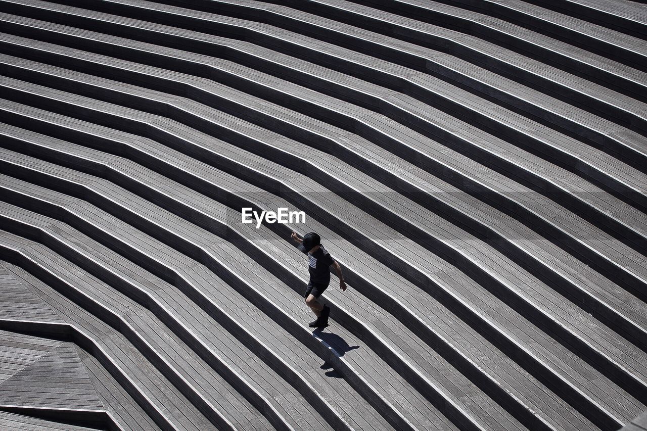 HIGH ANGLE VIEW OF MAN WALKING ON STREET