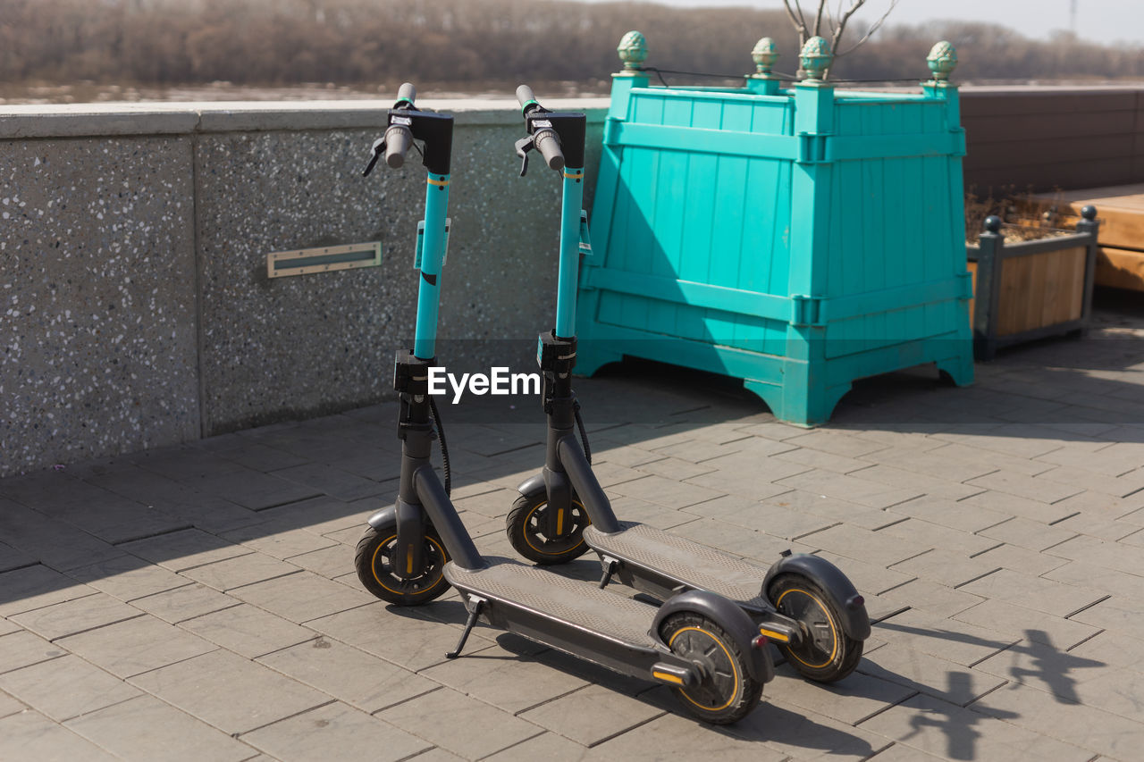 low section of man riding push scooter on footpath