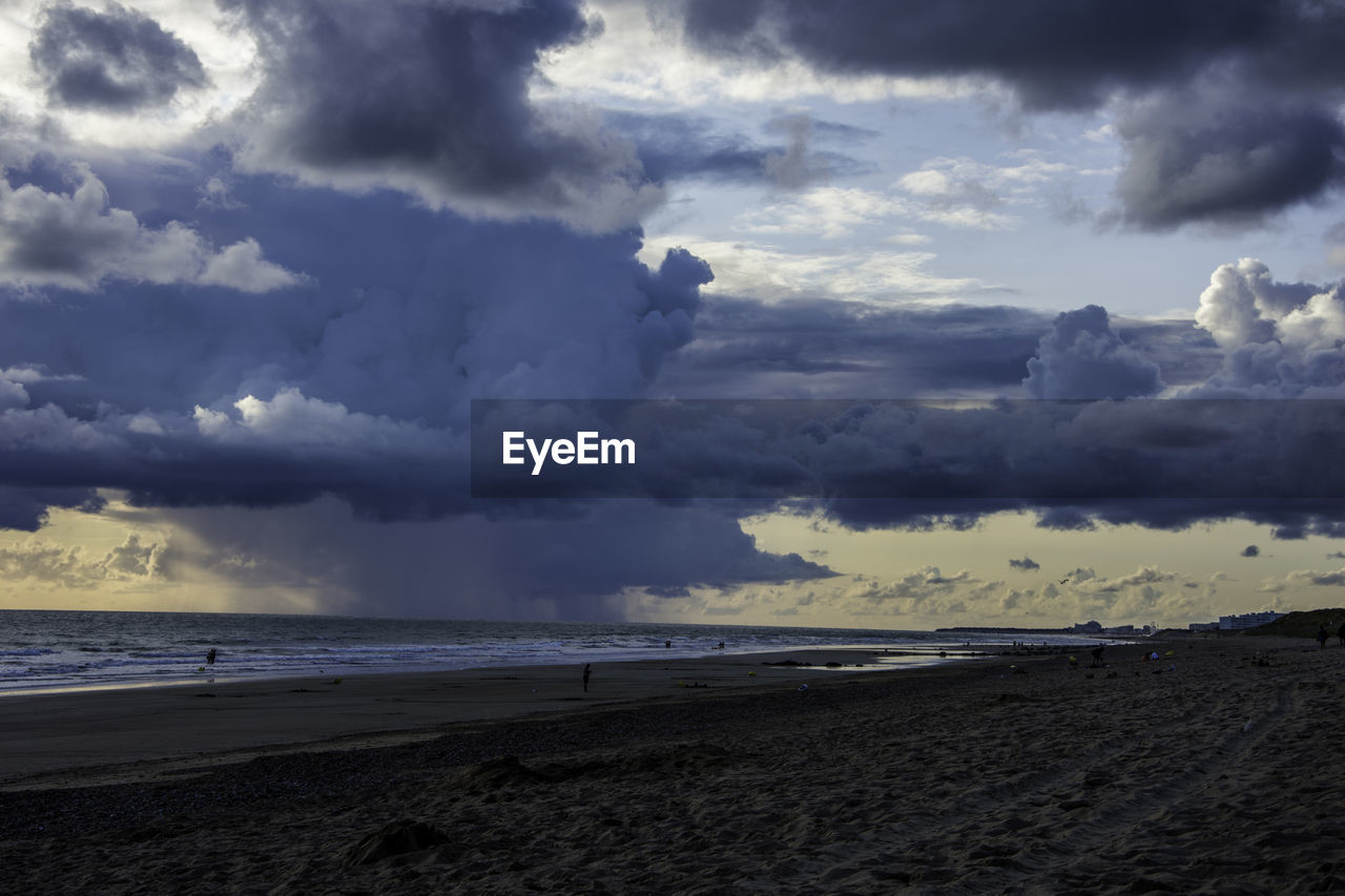 Scenic view of beach against cloudy sky