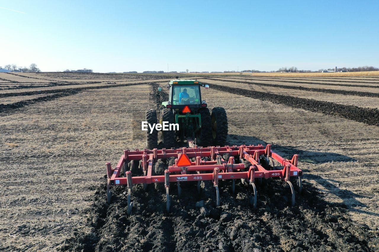 TRACTOR ON AGRICULTURAL FIELD AGAINST SKY