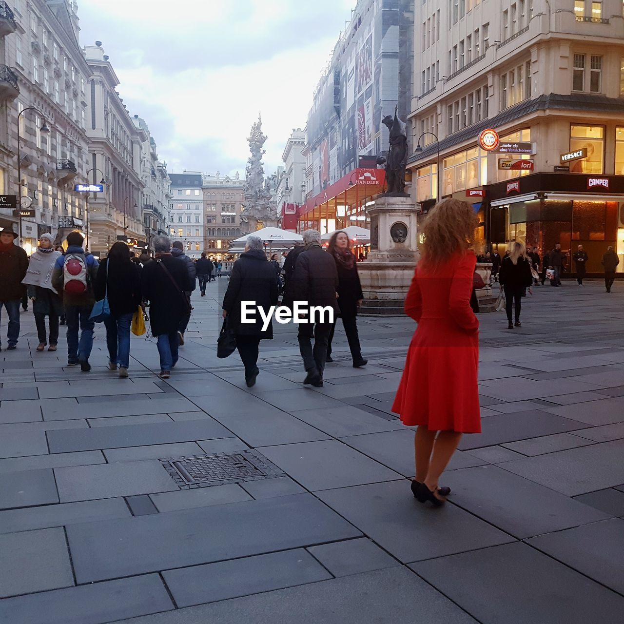 PEOPLE WALKING ON ROAD AGAINST BUILDINGS