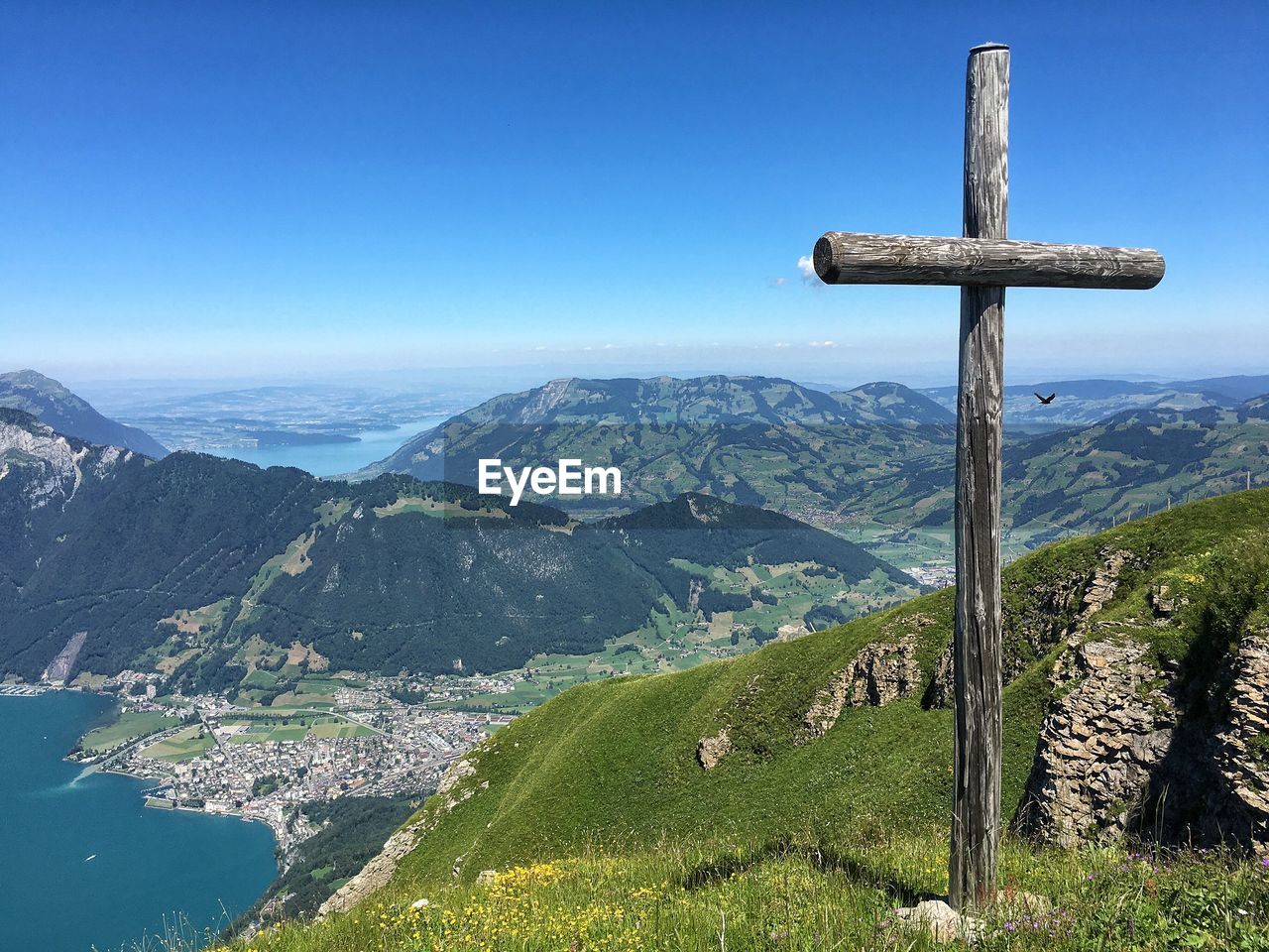 Wooden cross on top of mountain against blue sky