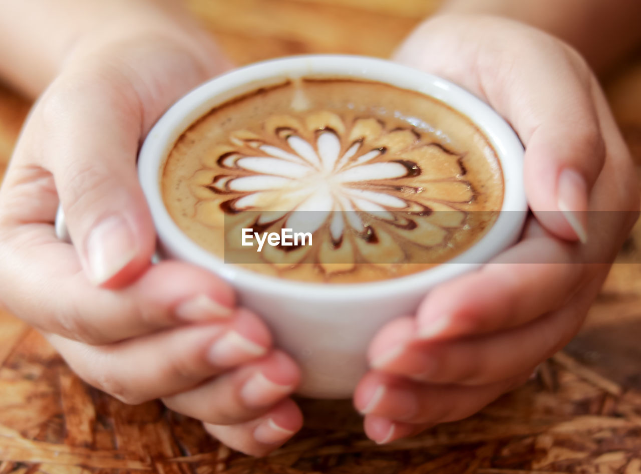 CROPPED IMAGE OF HAND HOLDING COFFEE CUP