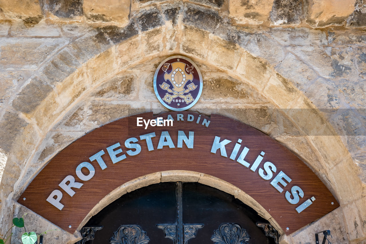 LOW ANGLE VIEW OF INFORMATION SIGN ON WALL OF BUILDING