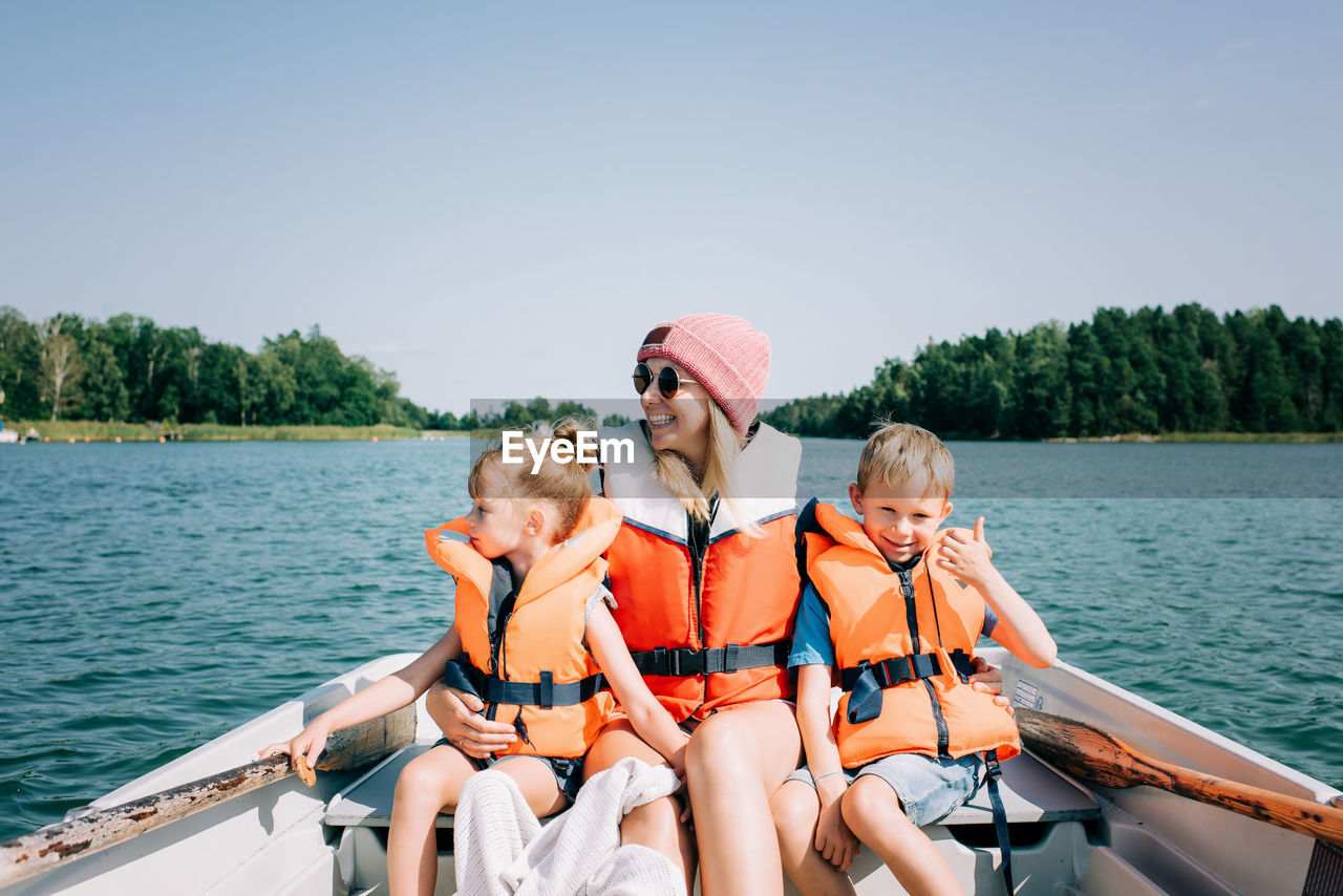 Mother sat happily with her kids on a boat enjoying summer in sweden