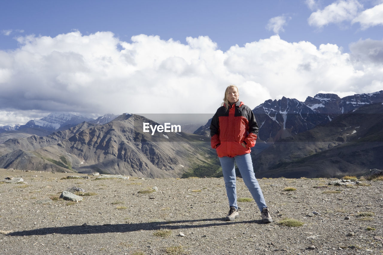 Woman standing on whistler mountain against cloudy sky