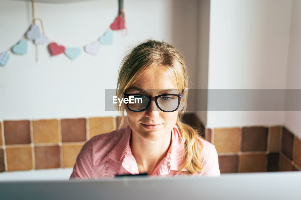 Smiling businesswoman working on computer at home