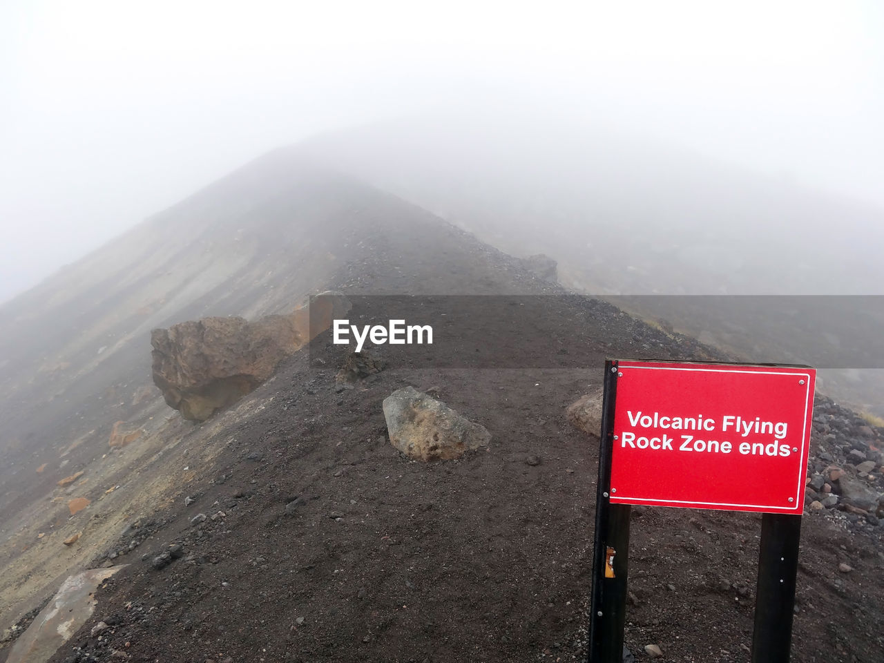 Information sign on mountain against sky