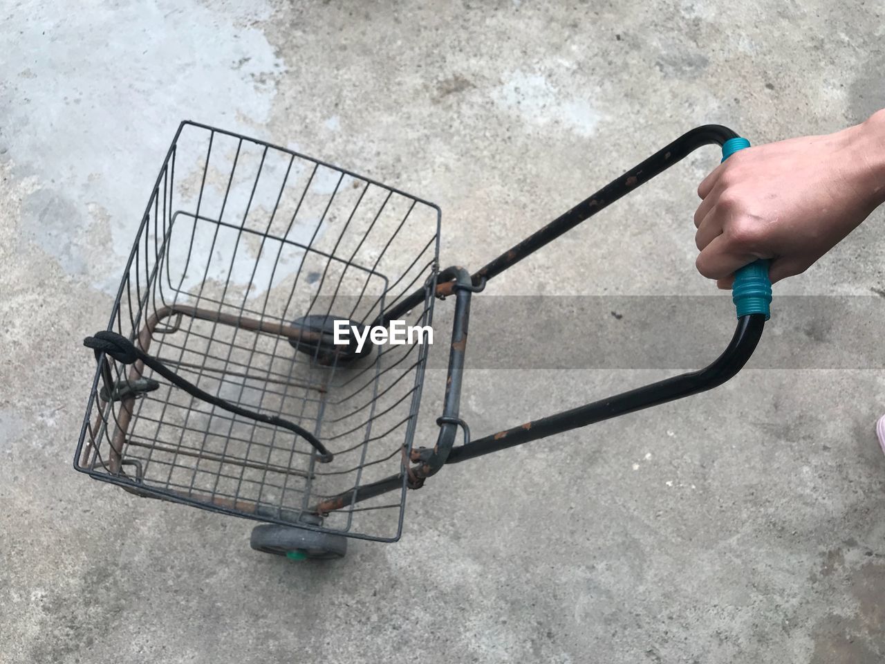 Cropped hand holding shopping cart