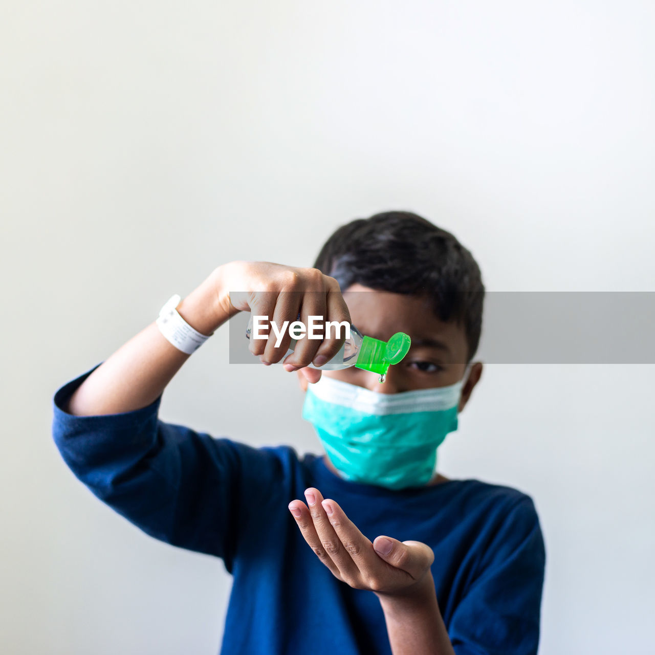 FULL LENGTH PORTRAIT OF BOY HOLDING HANDS AGAINST WHITE BACKGROUND