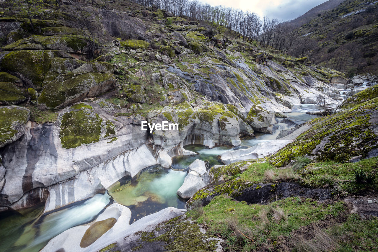 STREAM FLOWING THROUGH ROCKS IN RIVER