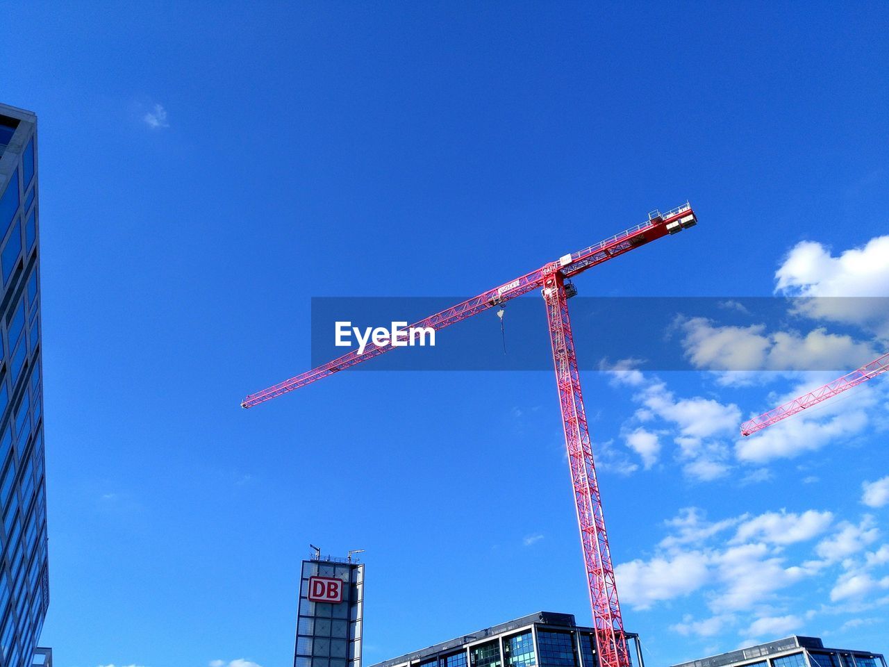 LOW ANGLE VIEW OF CRANES AT CONSTRUCTION SITE
