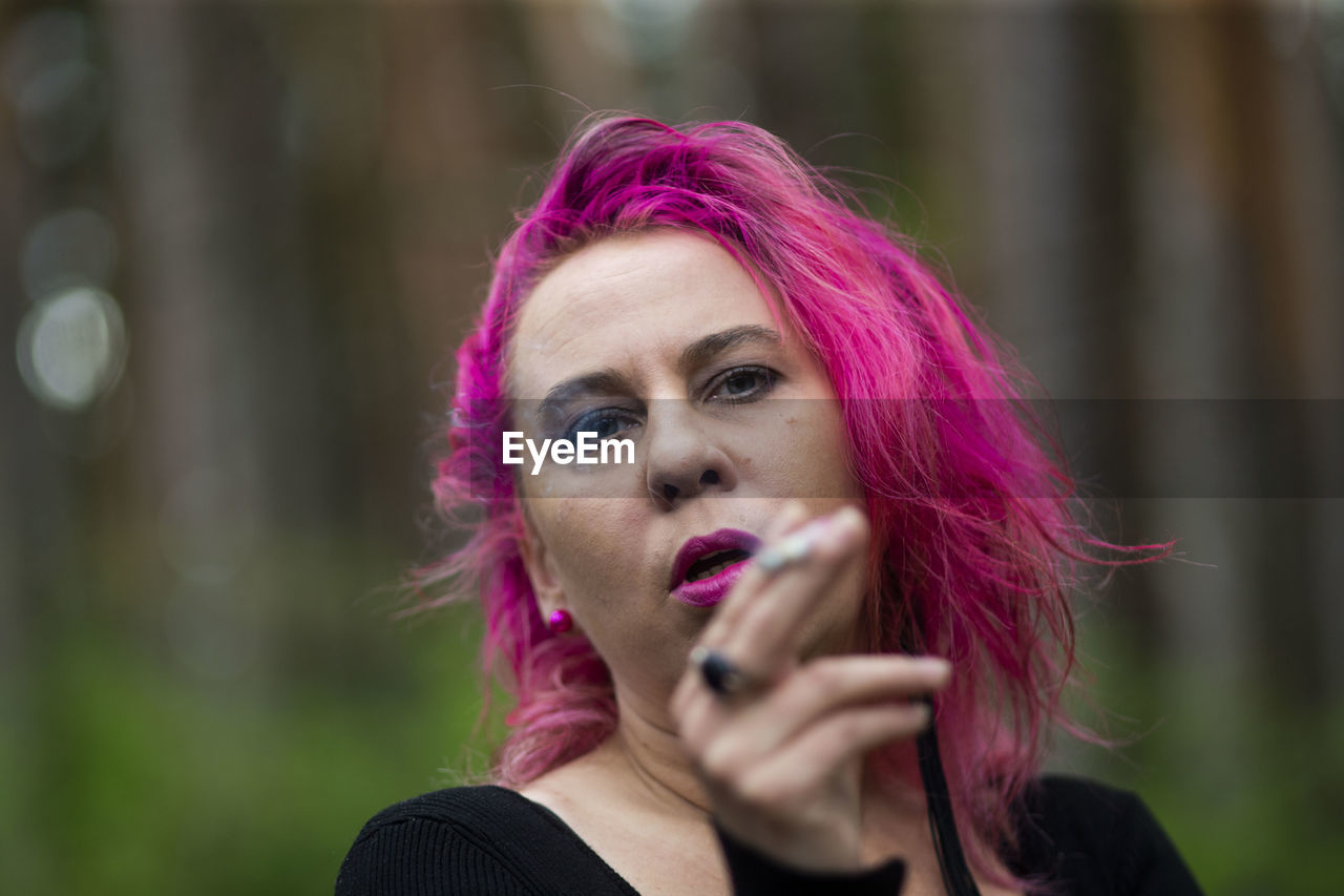 PORTRAIT OF BEAUTIFUL YOUNG WOMAN WITH PINK EYES