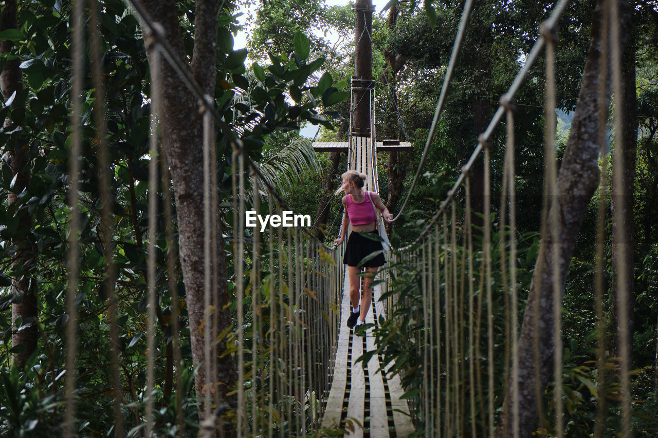 REAR VIEW OF WOMAN IN FOREST