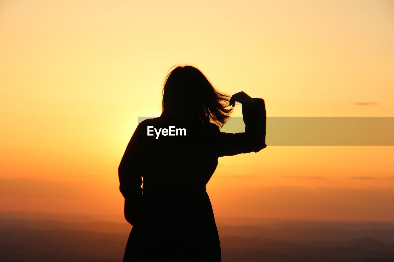 Silhouette woman standing against orange sky6