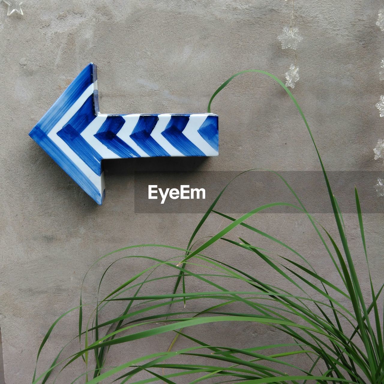 Close-up of blue arrow symbol mounted on wall