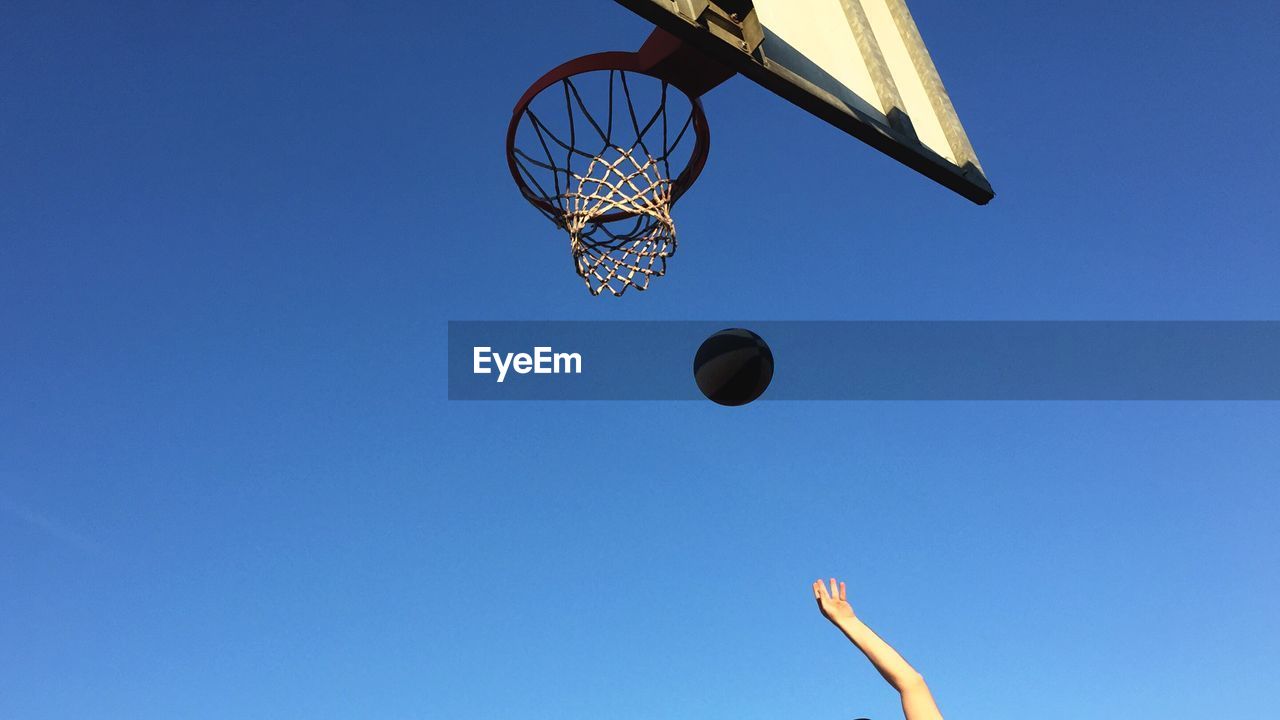 Low angle view of basketball hoop against clear blue sky