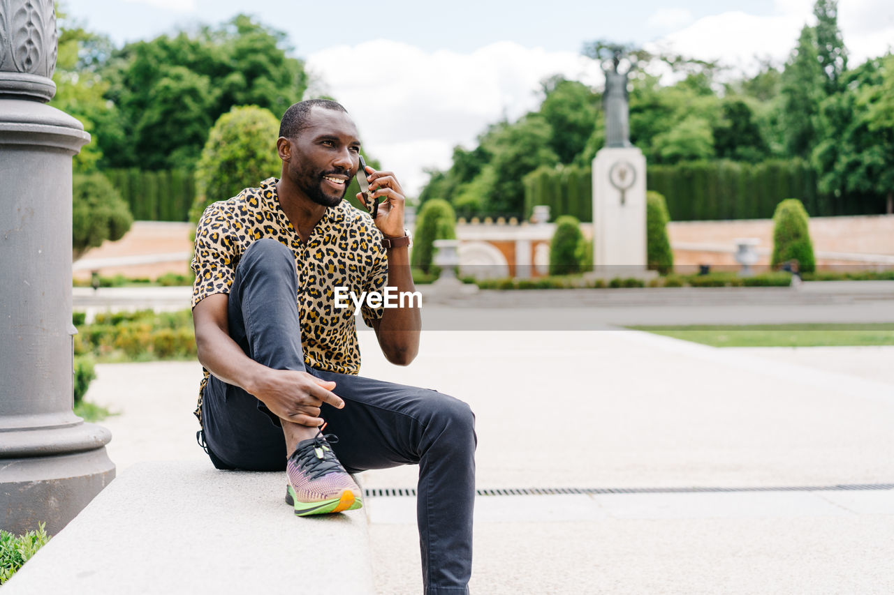 Positive afro american stylish man in european city