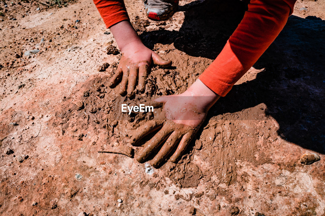 HIGH ANGLE VIEW OF PEOPLE ON MUD