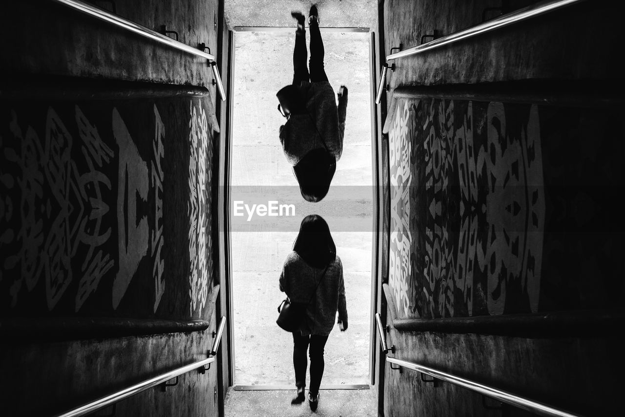 REAR VIEW OF MAN WALKING ON WALL