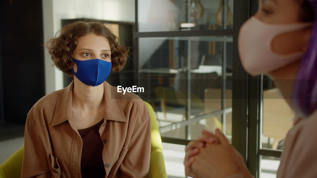 Businesswomen wearing mask sitting at office