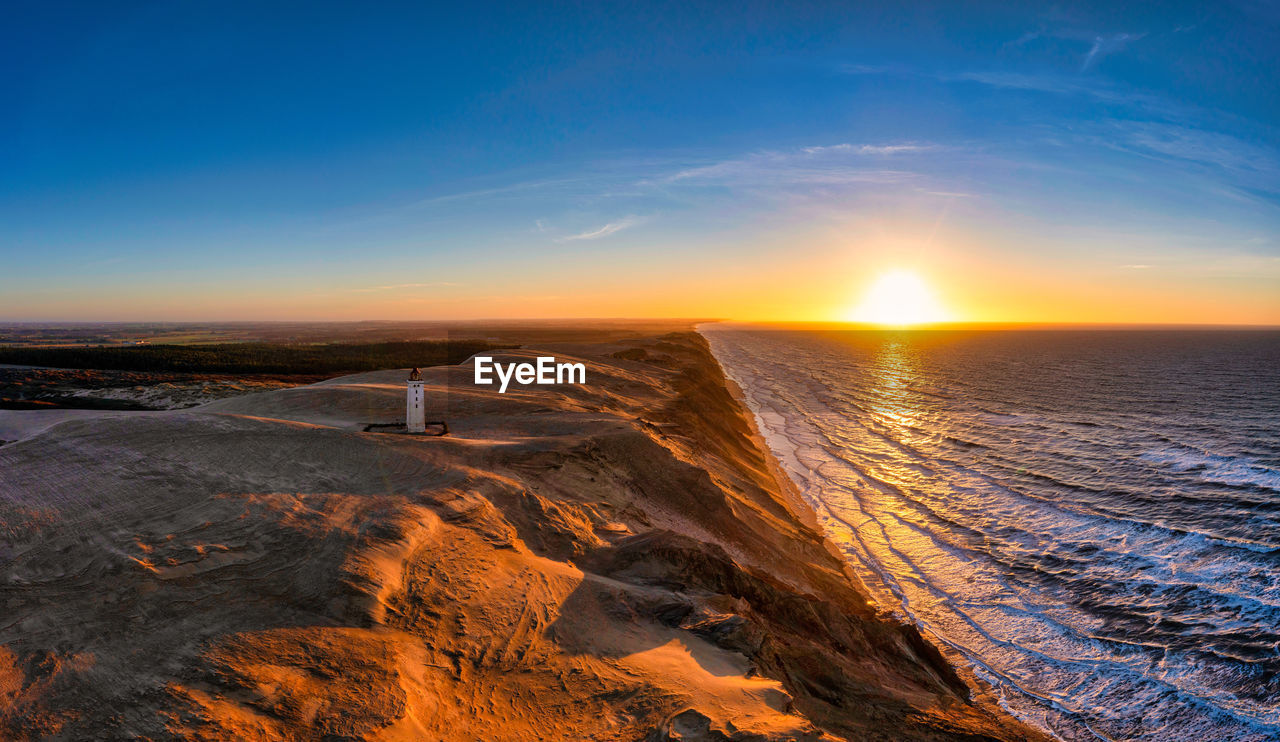 Rubjerg knude fyr lighthouse in sunset from drone