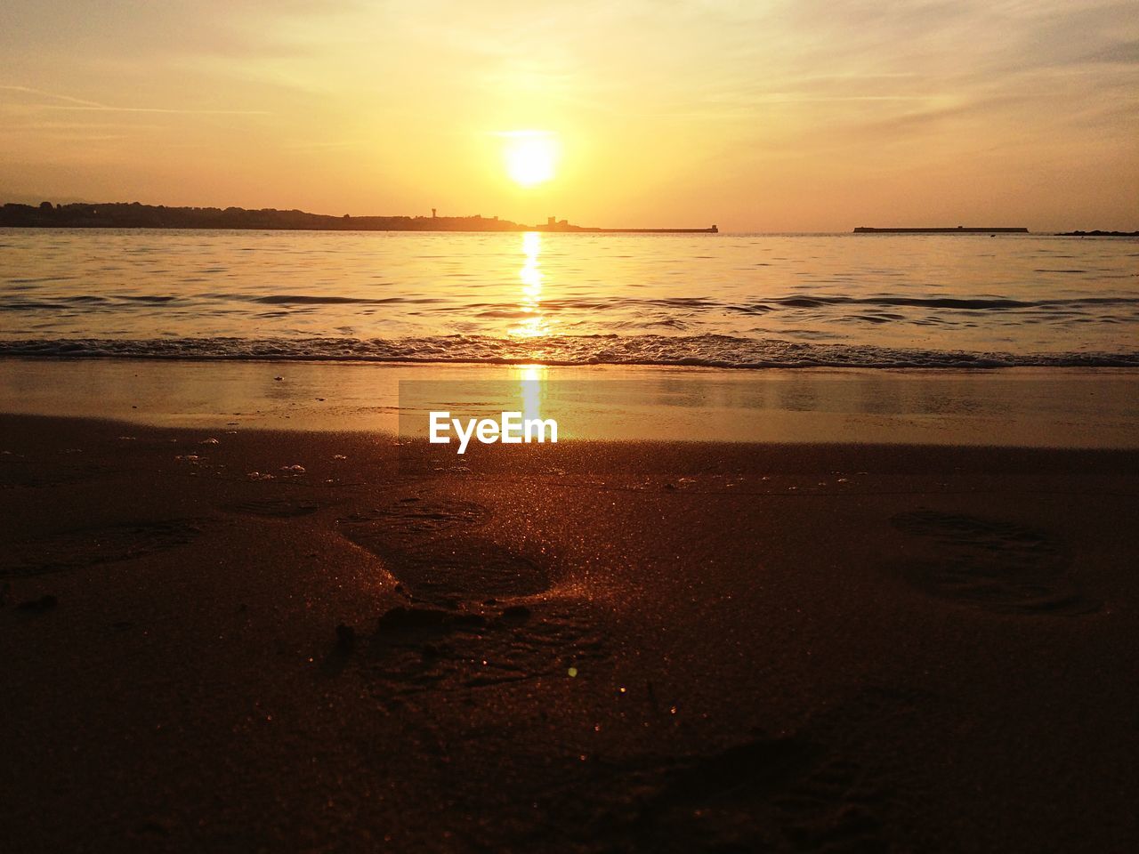 SCENIC VIEW OF BEACH AGAINST SKY DURING SUNSET