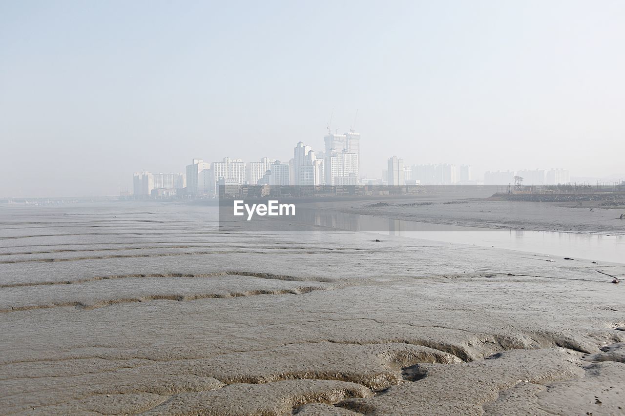 SCENIC VIEW OF SEA AND BUILDINGS AGAINST SKY