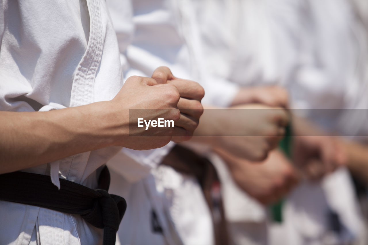 Midsection of people performing karate