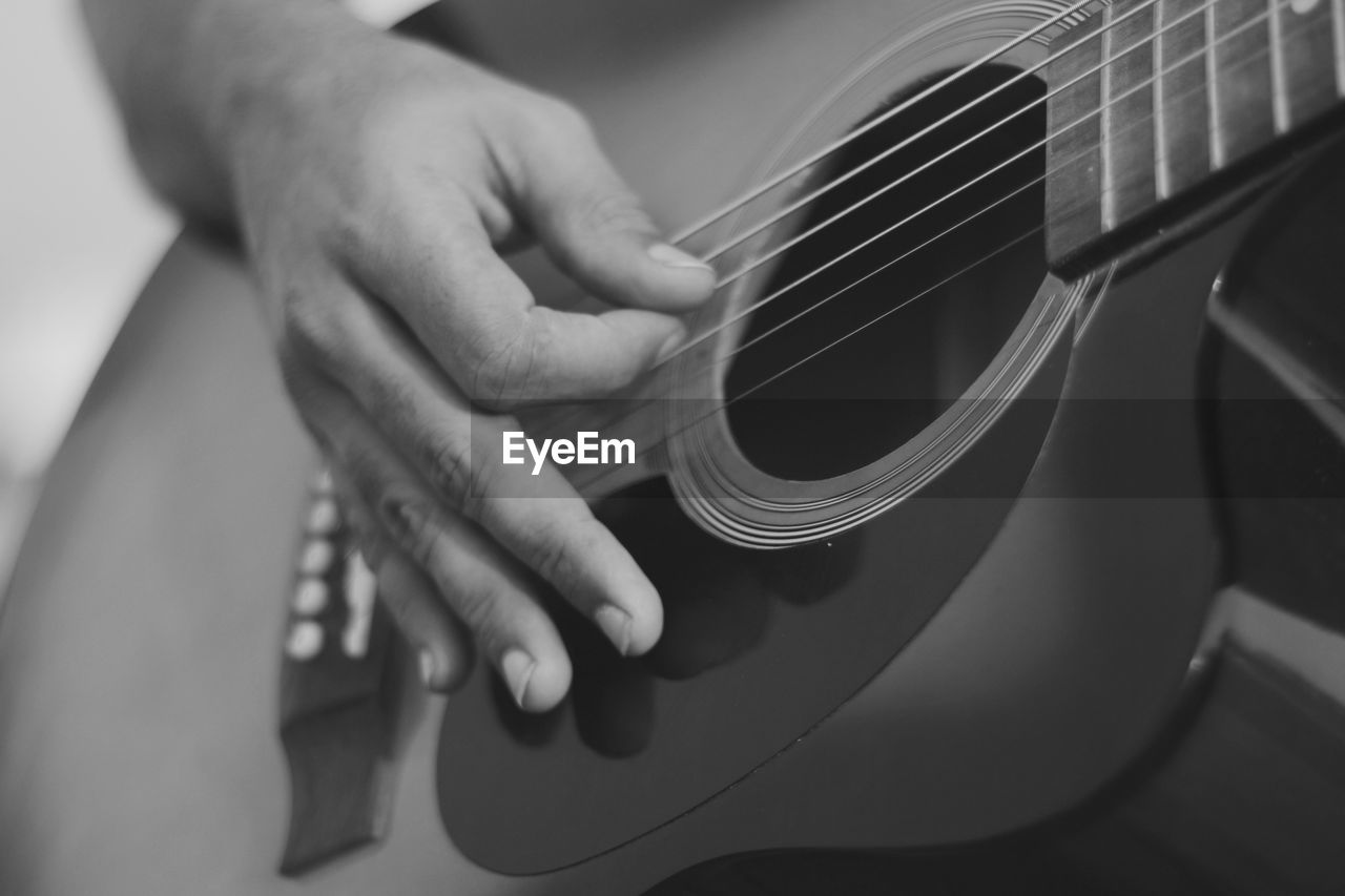 Cropped image of hand playing guitar