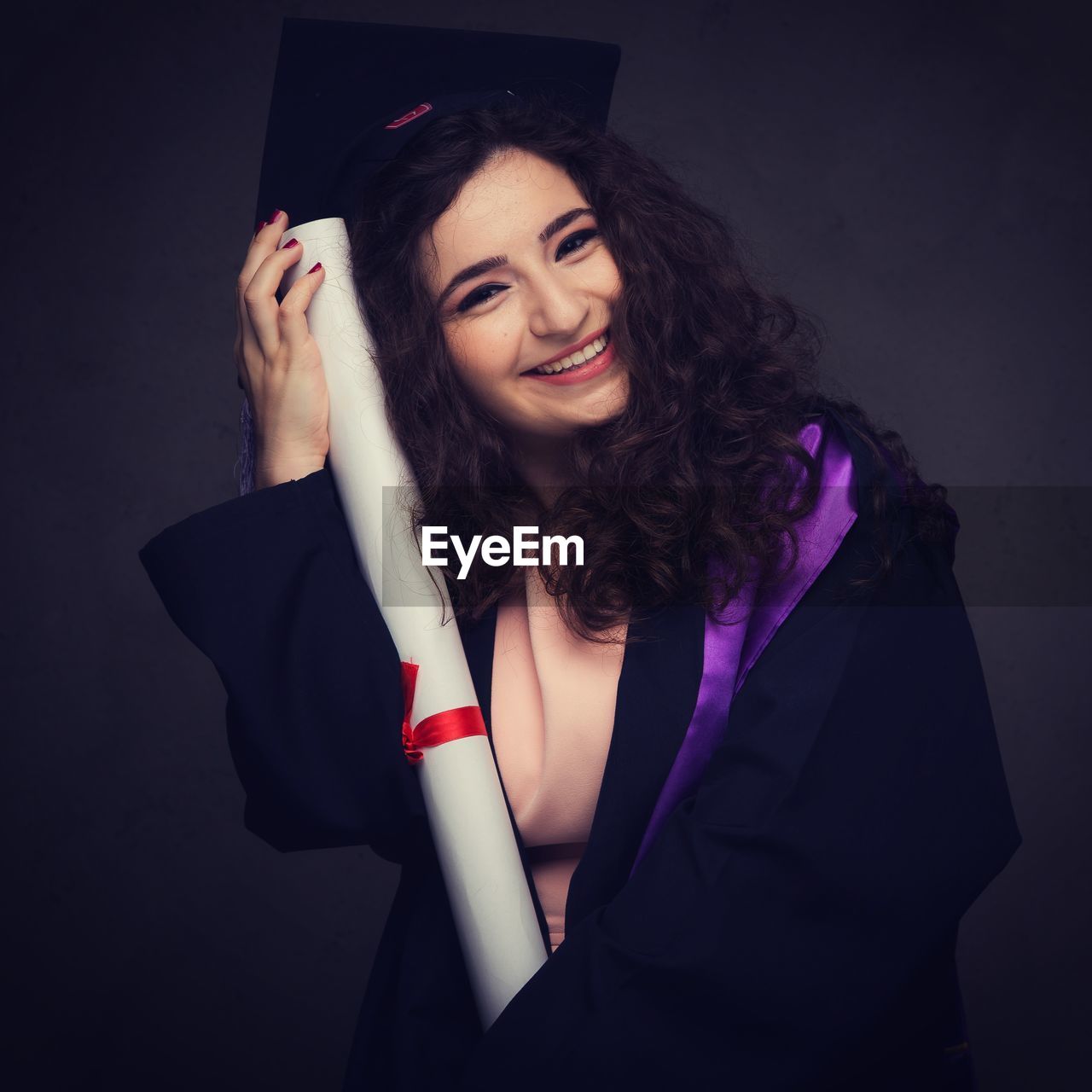 Portrait of smiling young woman in graduation gown