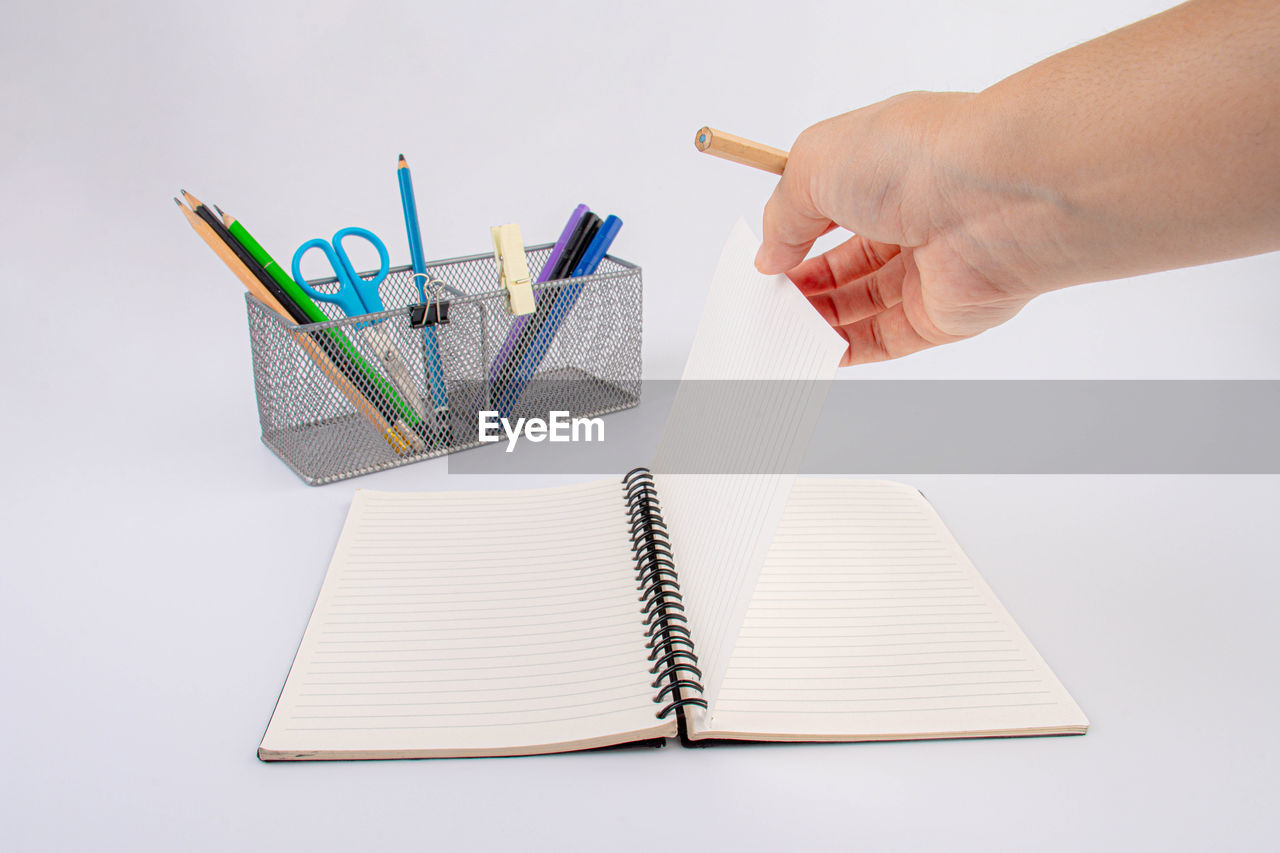 Hand with office pen and pencil holder. isolated on white background.