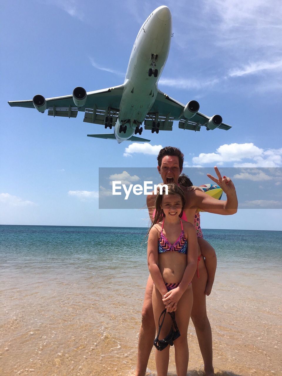 Airplane flying over family at beach